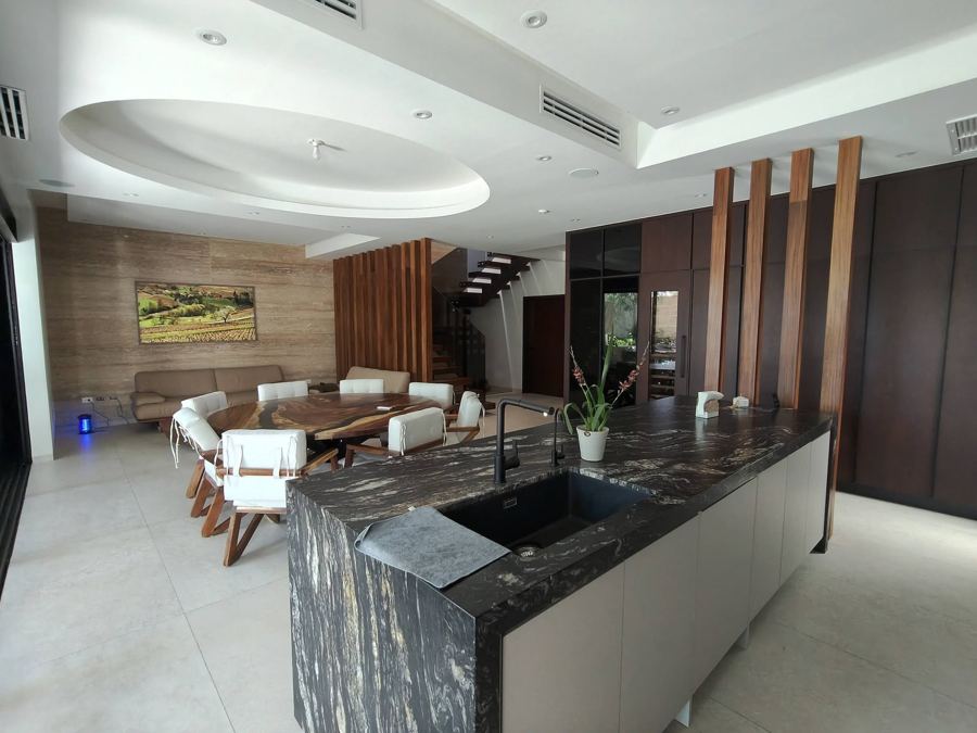 Cocina con isla de granito negro abierta al comedor